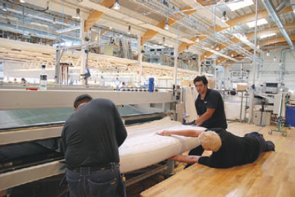 Mihilfe einer Maschinenpresse werden die Sprungfedern zusammengedrückt, damit die Bettmatraze mit Stoff bezogen werden kann. Bei dieser Präzisionsarbeit ist Flexibilität unabdingbar. Mihilfe einer Maschinenpresse werden die Sprungfedern zusammengedrückt, damit die Bettmatraze mit Stoff bezogen werden kann. Bei dieser Präzisionsarbeit ist Flexibilität unabdingbar.